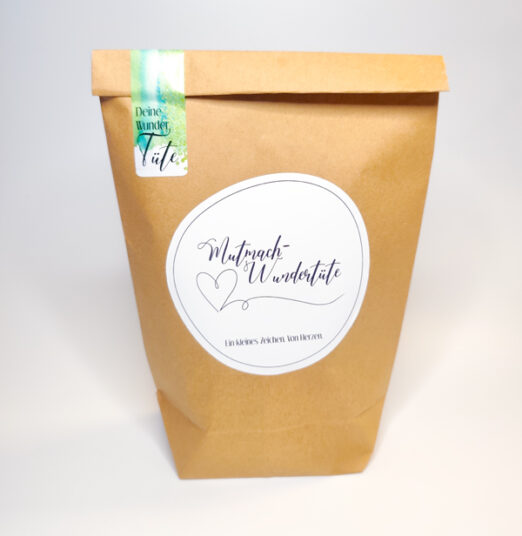 Mutmach-Wundertüte aus Kraftpapier mit Herz-Etikett.